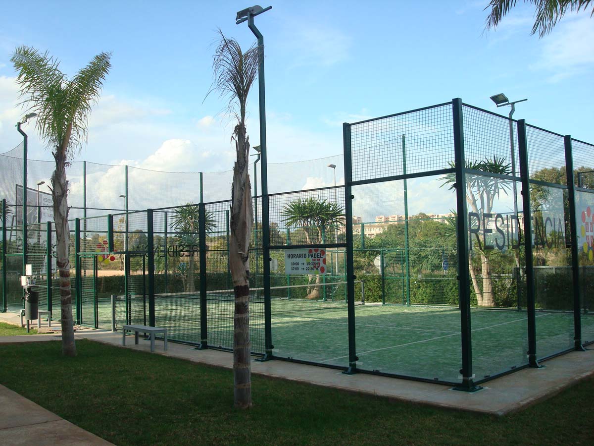Pista de pádel en una urbanización residencial con palmeras